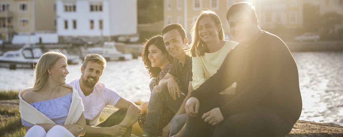Sex personer som sitter på en klippa i skärgården inne i Karlskrona.